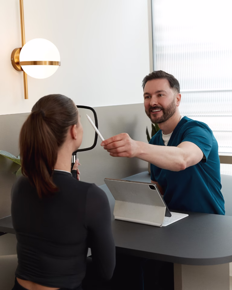 Dr Paul Elgey conducting a medical aesthetic consultation using facial assessment equipment.