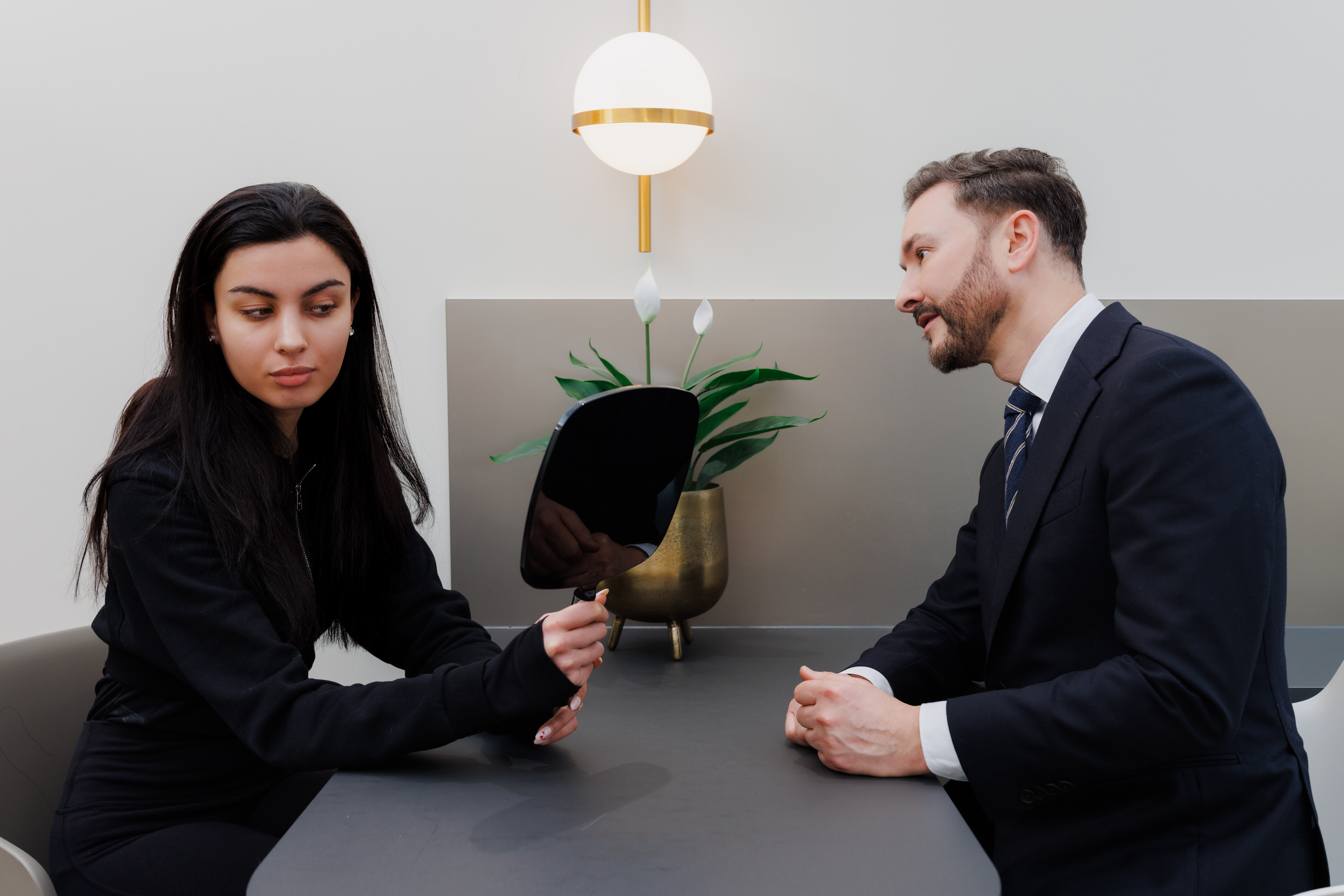 UltraClear laser consultation London patient examining skin with mirror during treatment assessment